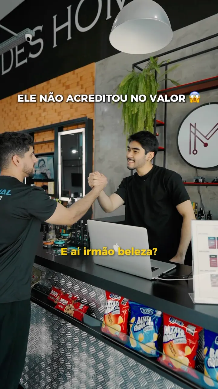 Cliente cumprimentando o atendente no balcão, com o M da marca na parede