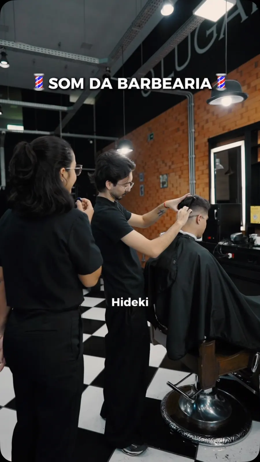 Barbeiro cortando cabelo no salão de piso xadrez e parede de tijolo